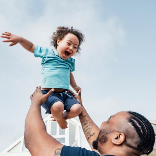 man holding child above his head